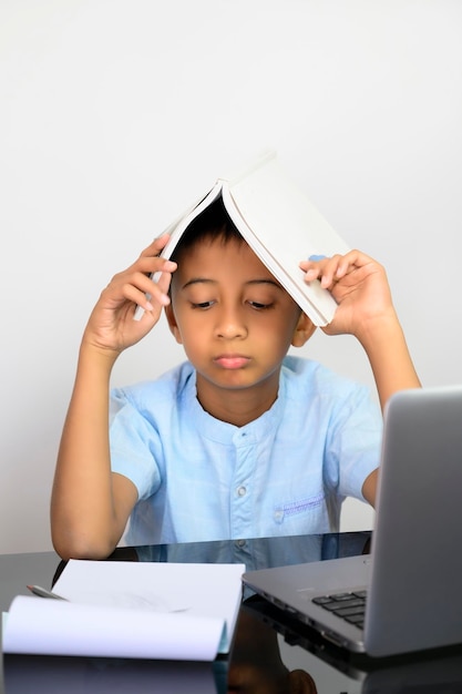 Photo young asian boy bored studying at home in this covid 19 pandemic