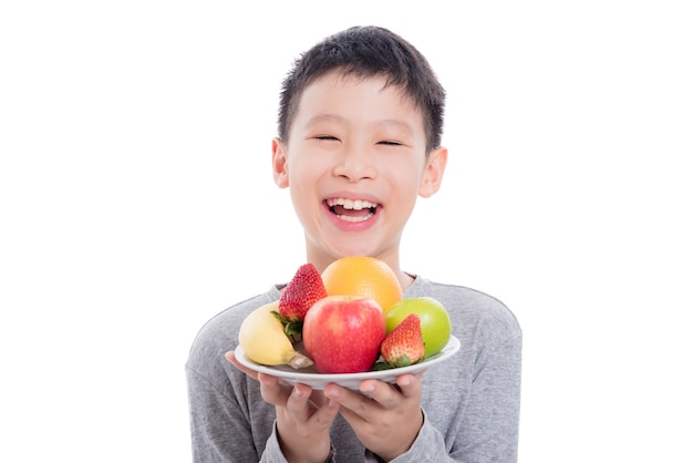 Young asian boy holding fruits and smiles