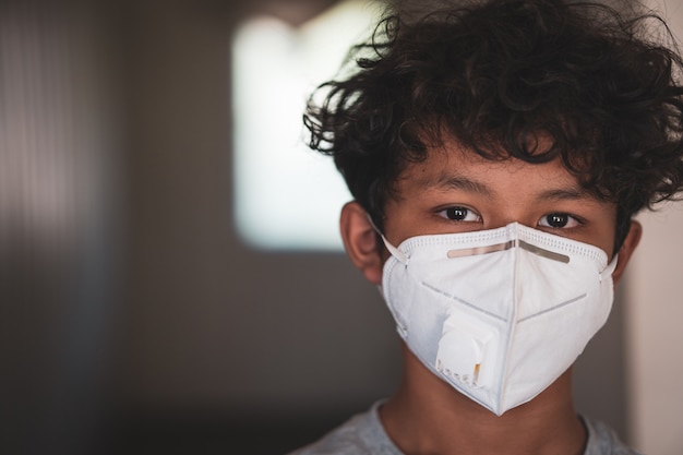 Young asian boy wearing a protective mask, fear over flu and coronavirus