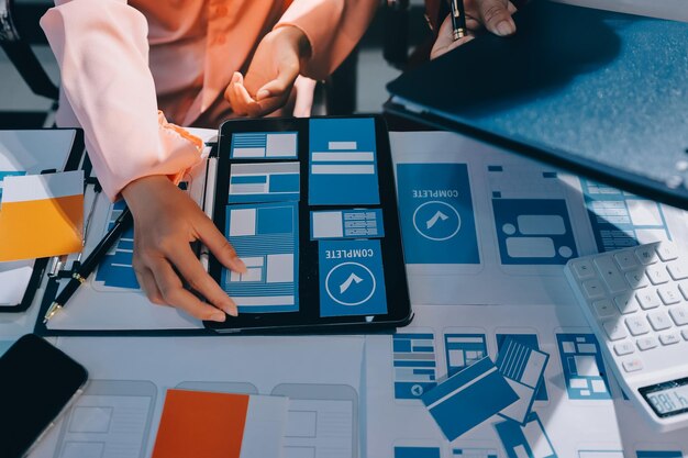 Young Asian business creative team work together mobile application software design project Brainstorm meeting internet technology smartphone web app designer office coworker teamwork concept