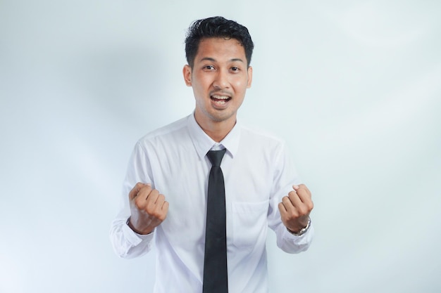 Photo young asian business man showing happy excited expression with clenched fist