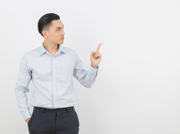 Young asian business man with blue shirt pointing to the side with a finger to present a product 