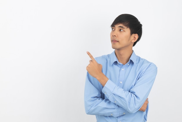 Young asian business man with blue shirt pointing to the side with a hand to present a product or an idea isolated on white background.