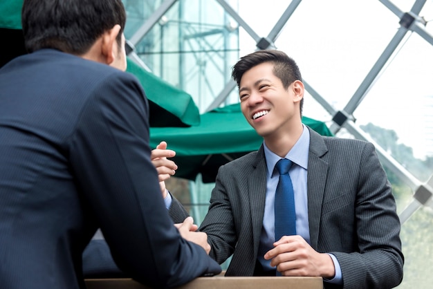 Young Asian business partners talking at cafe