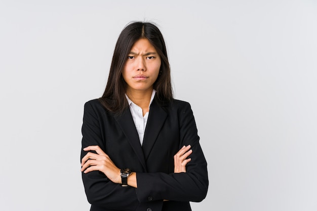 Young asian business woman frowning face in displeasure, keeps arms folded.