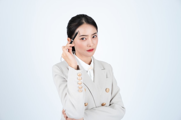 회색 양복에 젊은 아시아 비즈니스 여자는 똑똑하고 자신감입니다. 관리자는 일에 대해 생각하고 있습니다.