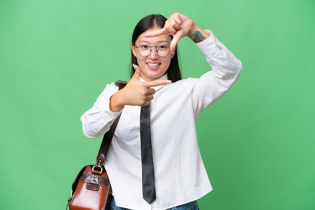 Young Asian business woman over isolated background focusing face Framing symbol