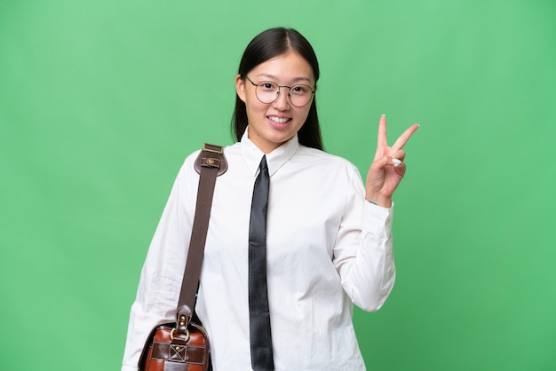 Young Asian business woman over isolated background smiling and showing victory sign