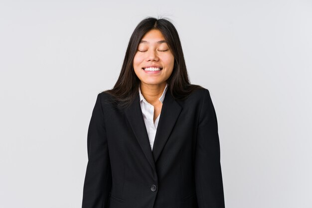 Young asian business woman laughs and closes eyes, feels relaxed and happy.