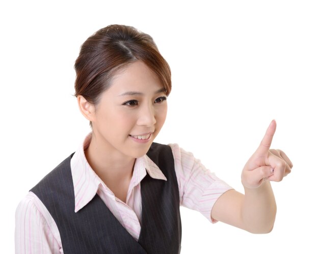 Young Asian business woman point and touch by finger, closeup portrait and focus on finger against white wall.