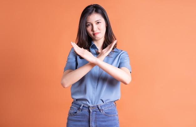 Young Asian business woman posing on orange background