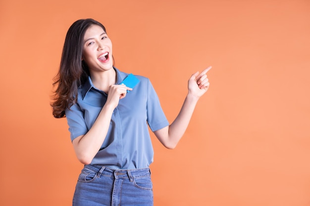 Young Asian business woman posing on orange background