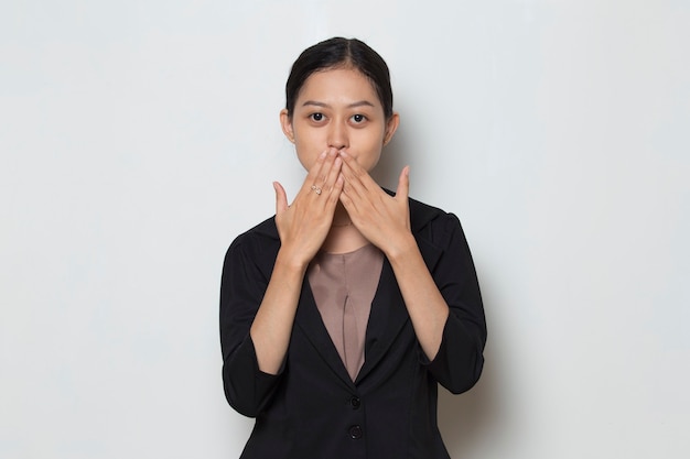 Young asian business woman shocked covering mouth with hands