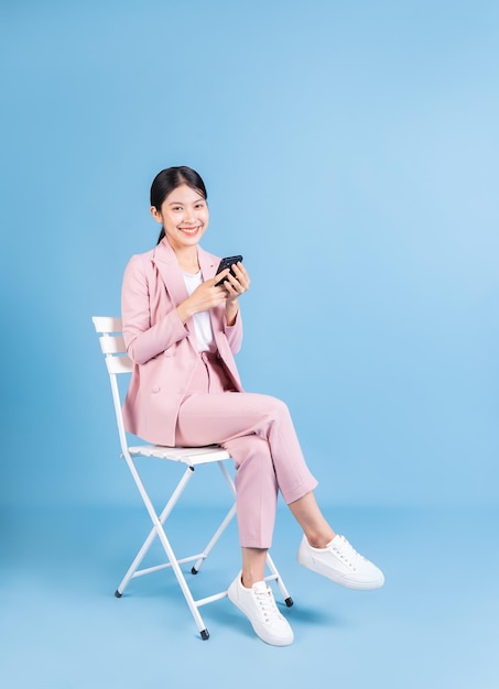 Young Asian business woman sitting on background