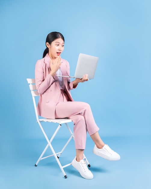 Young Asian business woman sitting on background