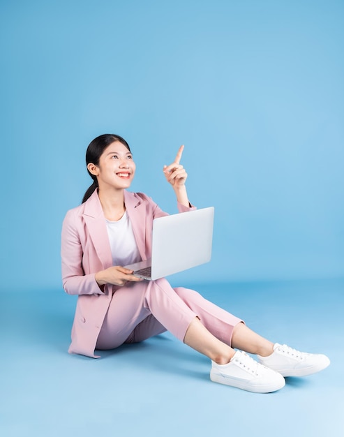 Young Asian business woman sitting on background