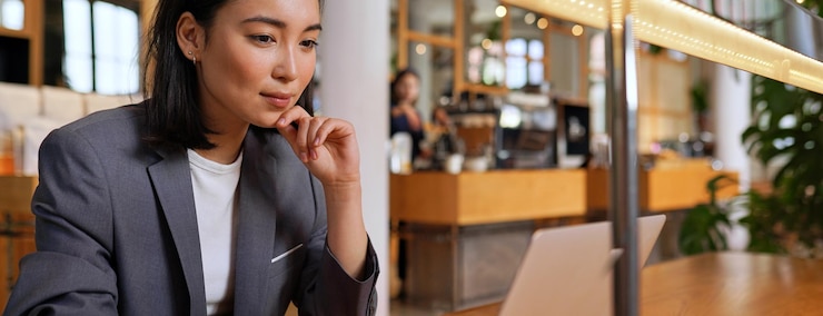 Photo カフェで昼食時にラップトップ コンピューターを使用して若いアジア ビジネス女性