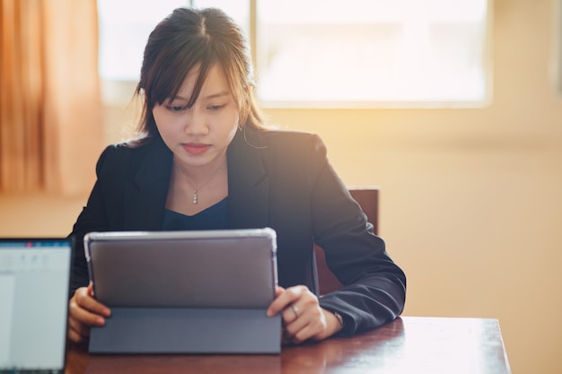 Young asian business woman working on tabet computer in the office