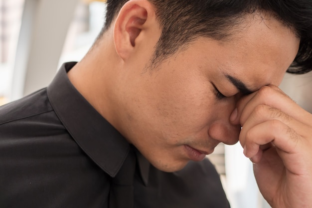 Young Asian businessman being sick