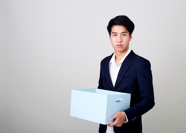 Young asian businessman holding a box