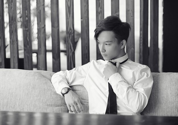 A young Asian businessman is waiting for a partner in a cafe. Business meeting in the restaurant. A Korean young man talking on the phone in a cafe.