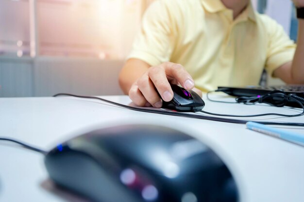 A young Asian businessman is working in the office The hand that holds the mouse to do the computer work busy and hectic work He is thinking about work