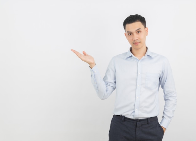 Giovane uomo d'affari asiatico che indica con un dito per presentare un prodotto o un'idea