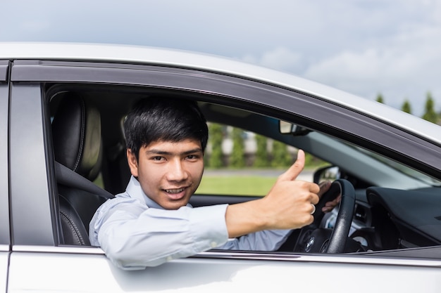 現代の車に座っている若いアジア人のビジネスマン