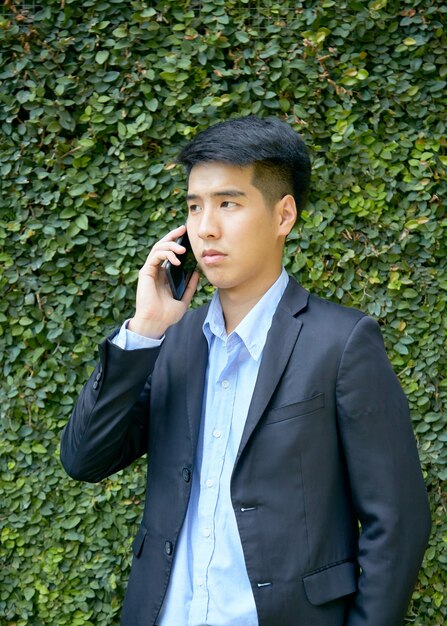 Young Asian businessman sitting in the park