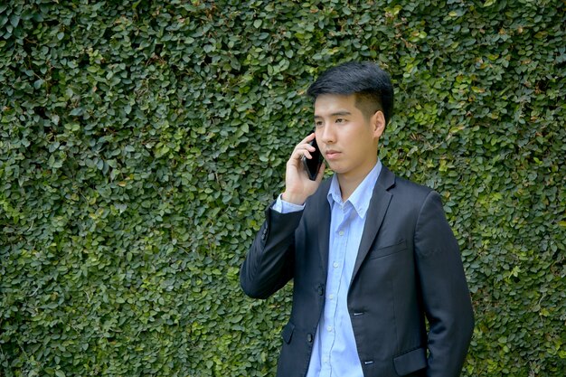 Young Asian businessman sitting in the park