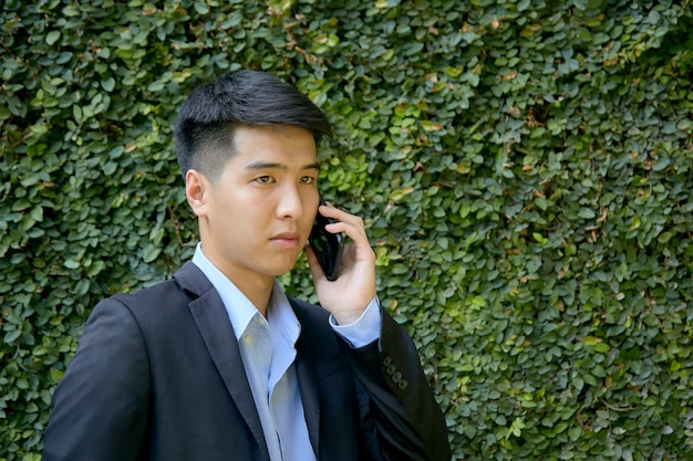 Young Asian businessman sitting in the park