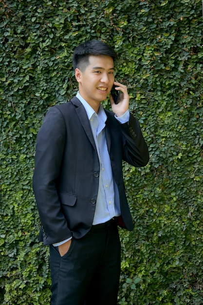 Foto giovane uomo d'affari asiatico seduto nel parco