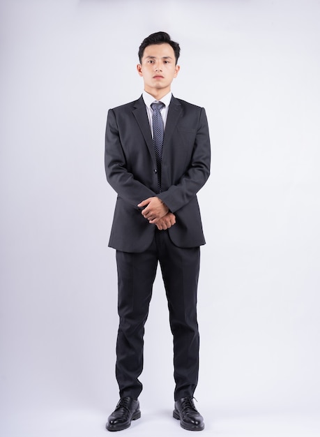 Young Asian businessman standing on white