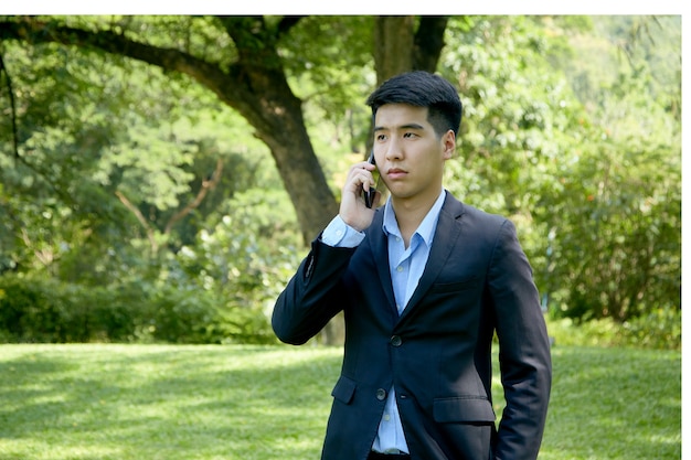 Young Asian businessman walking in the park