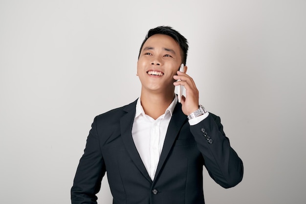 젊은 아시아 사업가 현대 양복을 입고 흰색 위에 휴대 전화에 대 한 이야기