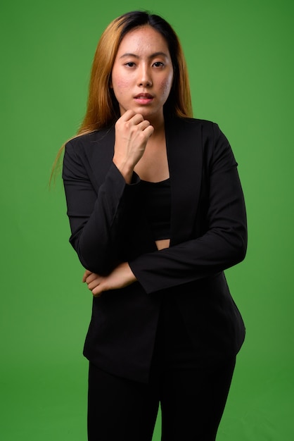 young Asian businesswoman against green space