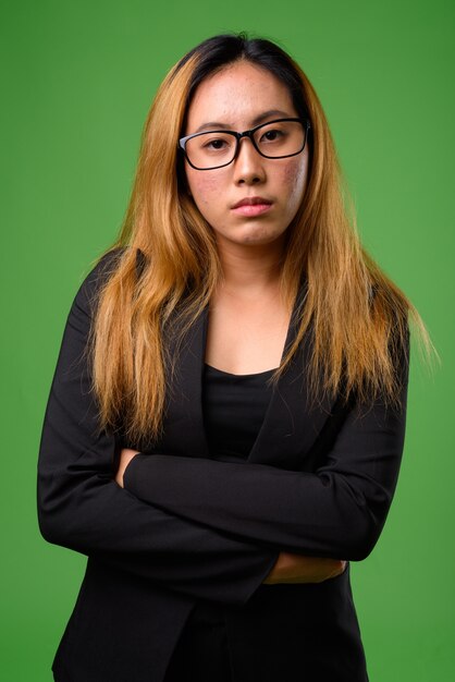 Young asian businesswoman against green space