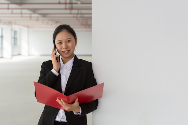 Young asian businesswoman holding a file folder studio shot isolated on white background