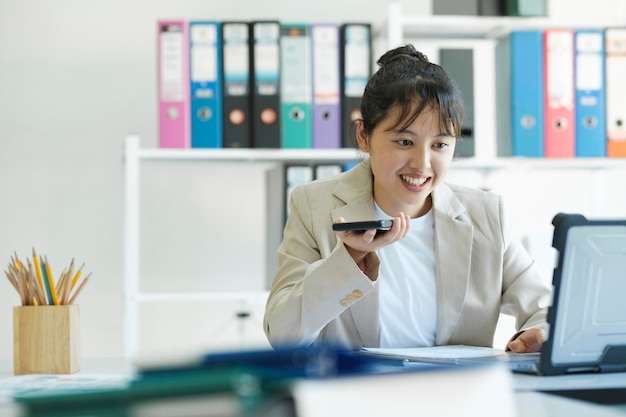 Young Asian businesswoman is working at office using mobile phone