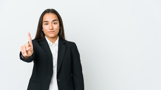 Young asian businesswoman isolated on white wall showing number one with finger.