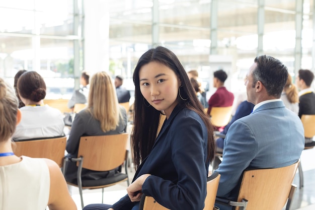 写真 若いアジアのビジネスウーマンが会議室に座ってカメラに微笑んでいました