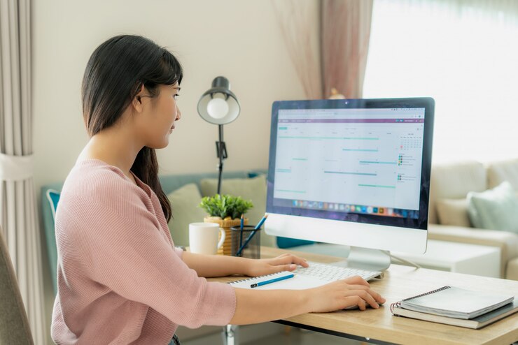自宅からコンピューター作業を使用して若いアジア女性実業家