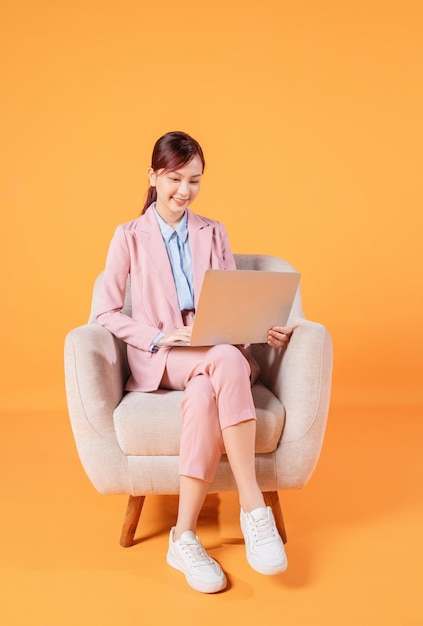 Young Asian businesswoman using laptop on background