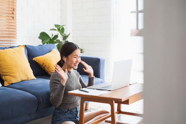 Photo young asian businesswoman work at home and virtual video conference meeting with colleagues business people online working video call due to social distancing at home office