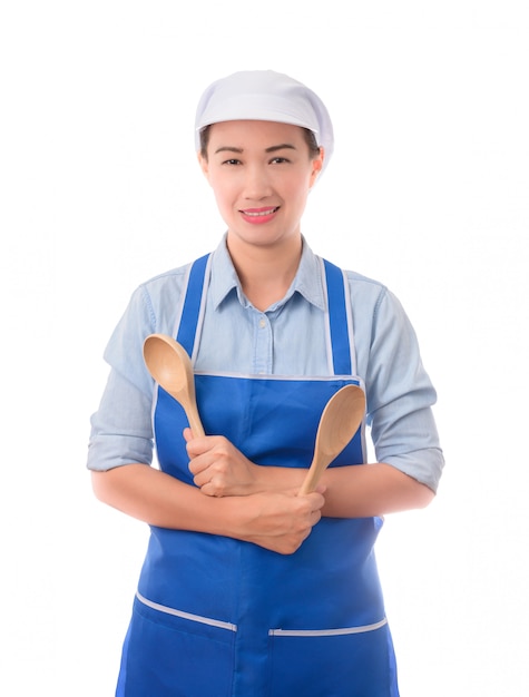 Молодой азиатский шеф-повар, домохозяйка уверенно позирует и держит шпатель в фартуке