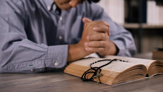 Молодой азиатский христианин молится Иисусу Христу в церкви