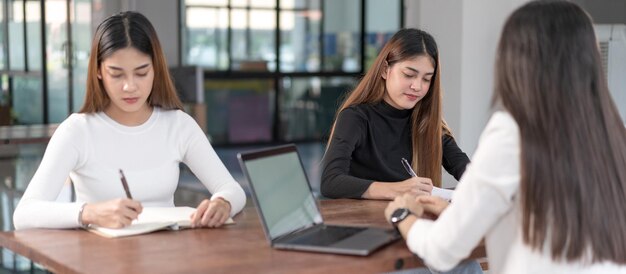 I giovani studenti universitari asiatici hanno un incontro con il tutor o il tutor dell'insegnante per discutere del progetto