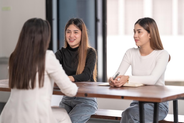 Young Asian college students have meeting with teacher advisor or tutor to discuss project