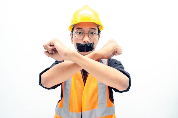 Young asian construction worker doing protest by covering mouth with tape isolated over white