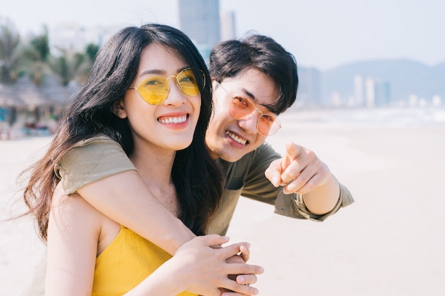 Young Asian couple enjoying summer vacation on the beach